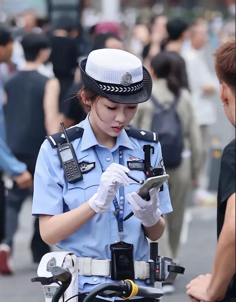 交警第一美女，认真查骑电动单车的女警真漂亮，也不崇洋媚外，还用着国产的华为手机。