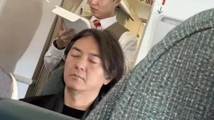 57岁郑伊健经济舱被偶遇，头发花白发量稀疏，全程闭目养神显疲惫