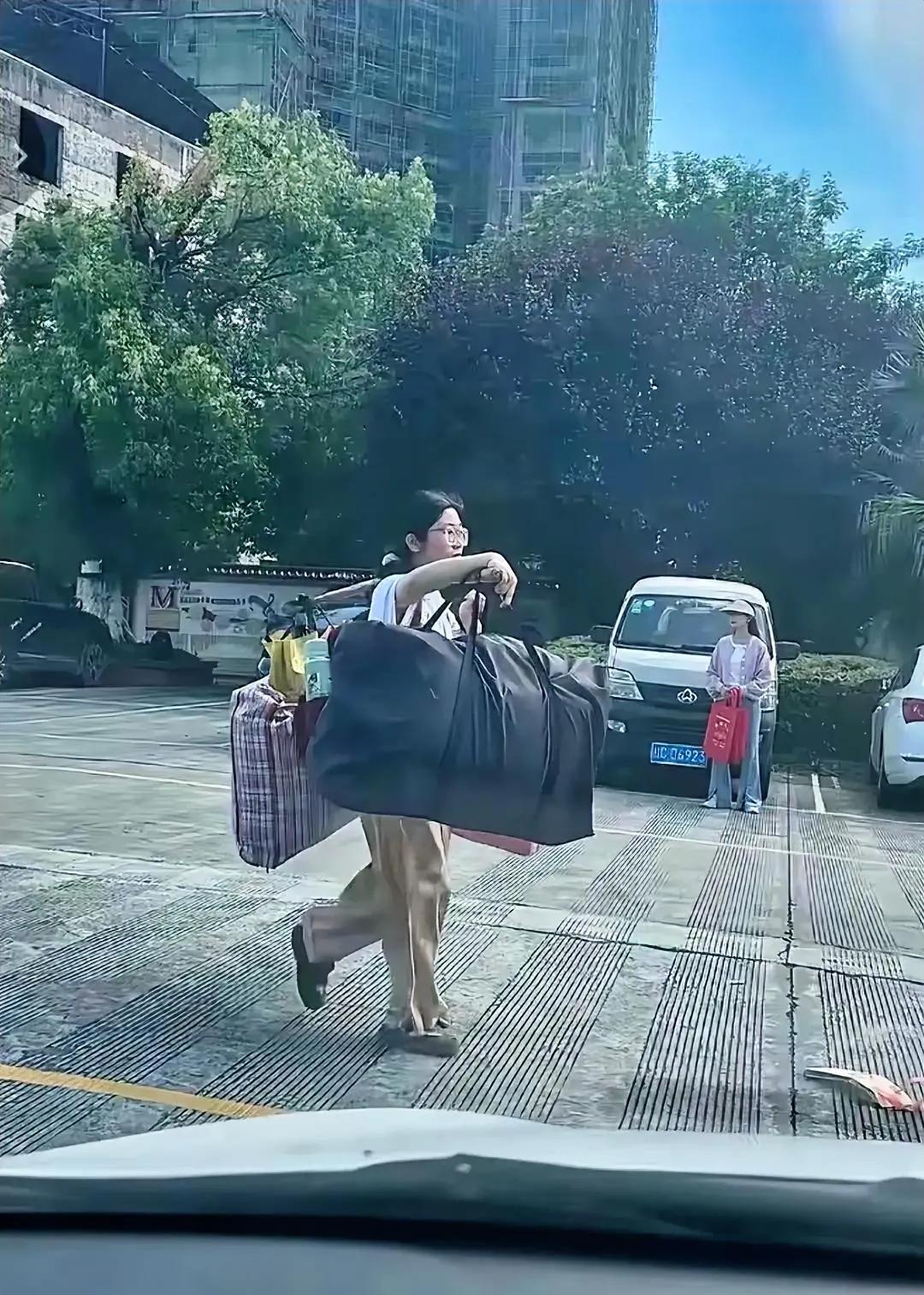 高考结束后，这位戴眼镜的女孩，在没有任何人帮助的情况下，独自一人用扁担挑着行李往