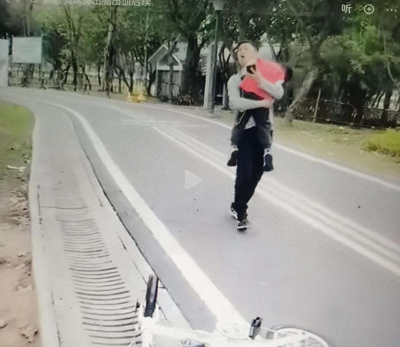 揪心！一小男孩骑车摔倒昏迷不醒，年轻爸爸抱着孩子慢吞吞呆在原地不动，还不打120