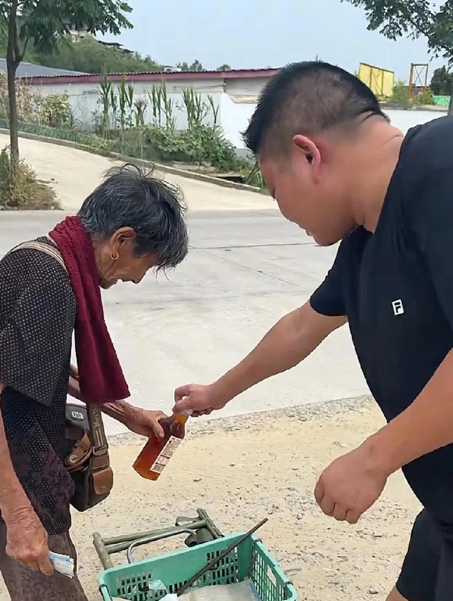 白发斑斑的老人，顶着近40度的高温，拖着一筐菜沿路叫卖，陌生男子走过去拦住了老人