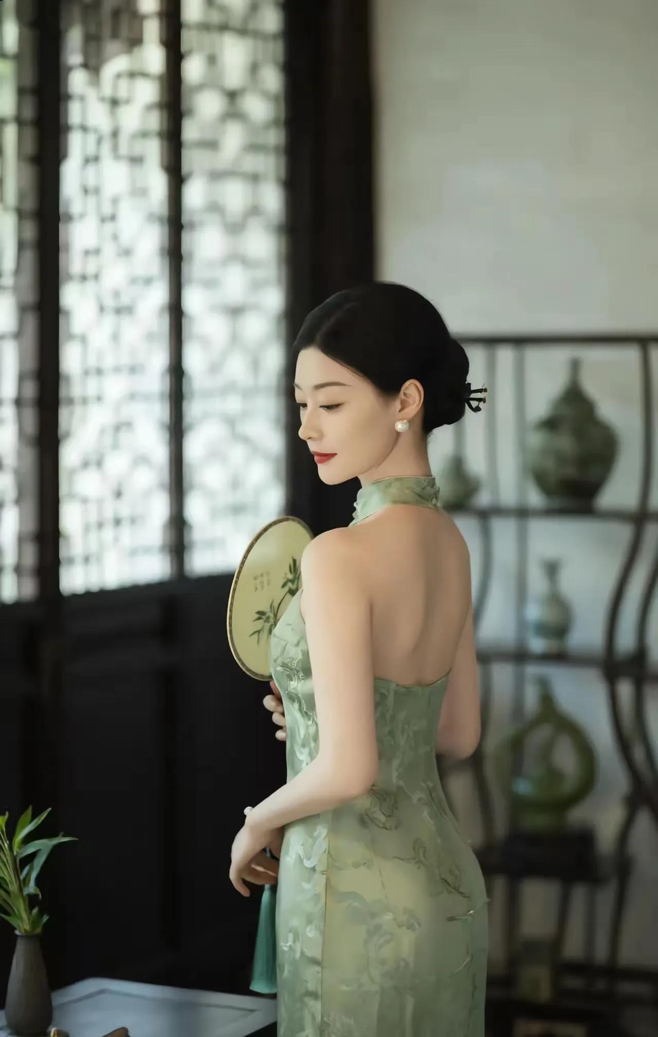 国风佳人
蓝绿旗袍映背娇，
玉扇云鬓韵迢迢。
窗光古器相陪处，
裁取月光诗里飘。