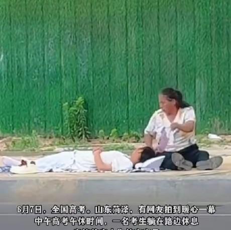 上午的考试结束了，找一个空闲的路边铺上一块布，让孩子休息一会儿，母亲摇着扇子，让