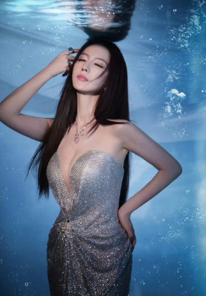 一袭紫色礼裙缀满碎钻与羽毛，露背剪裁勾勒曼妙曲线，行走间宛如流动的银河。不堆砌不