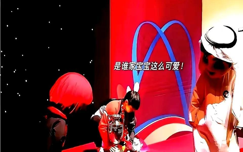 这张照片绝了！俩吉祥物猫着腰，脑袋凑一块儿直勾勾盯着中间那姑娘，那偷偷摸摸的架势