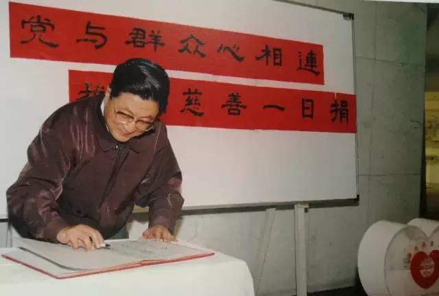 1999年2月9日，黄菊参加上海市委机关“慈善一日捐”活动。背景上面写的是:党与