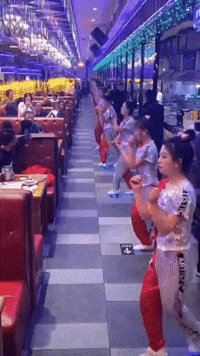 端午假期的美食城，顾客来来往往、熙熙攘攘……面容较好的打工妹前来跳舞助兴，食客们
