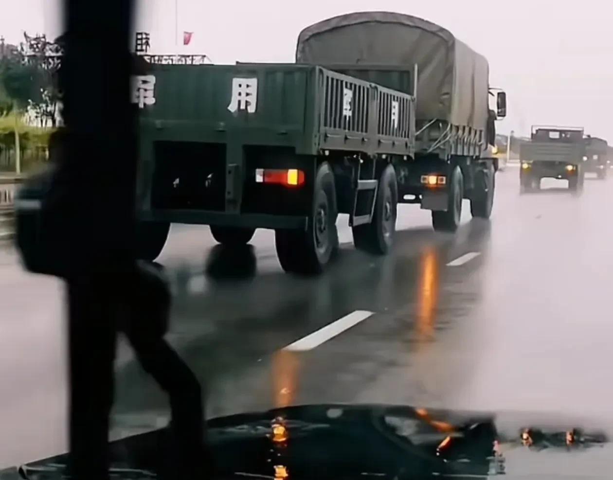 路上偶遇部队的车队，车队中车绑子上写着“军用”二字的传统全挂车被卡车牵引的画面太