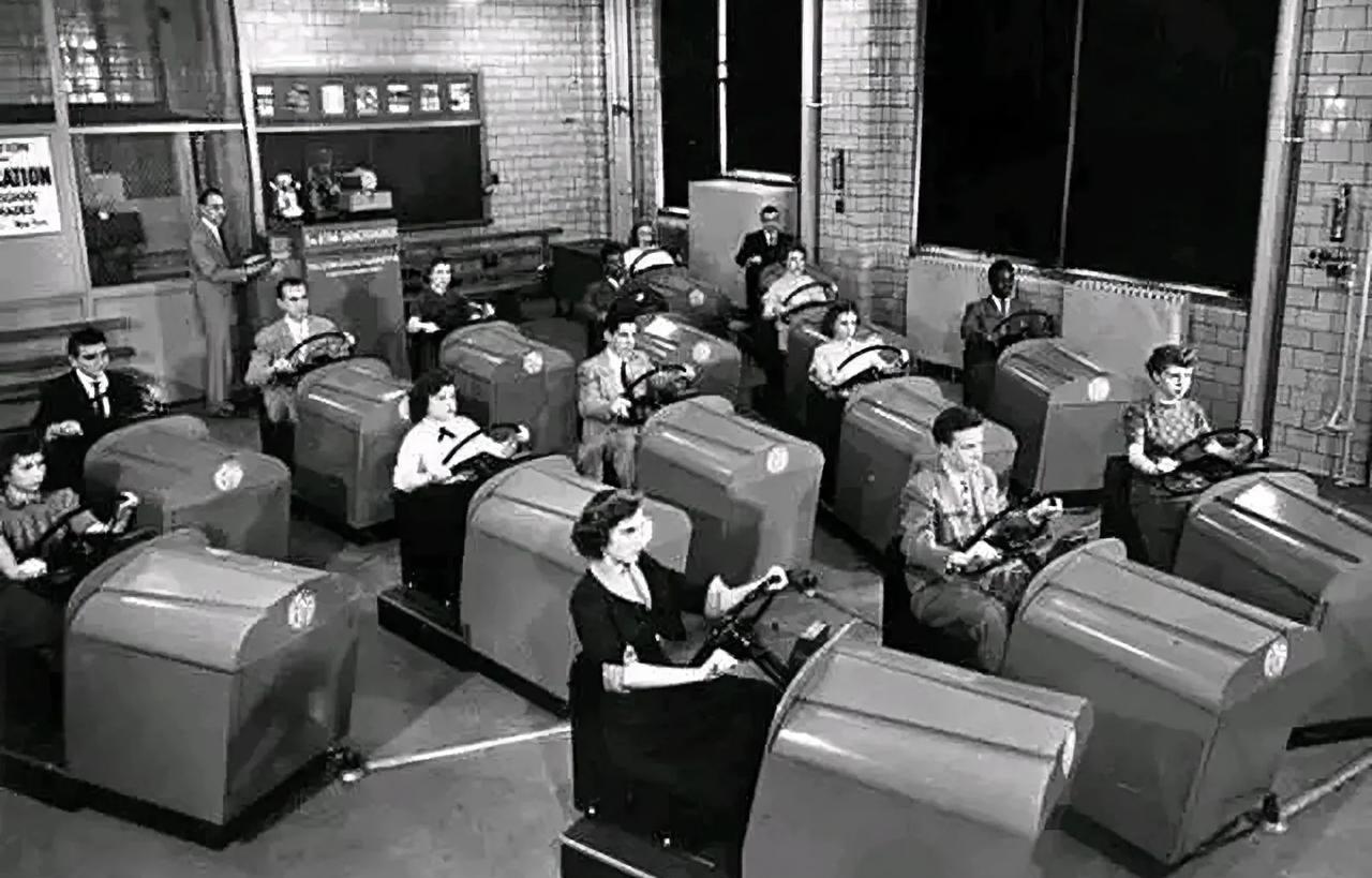 上世纪五十年代，美国一家驾校学员在模拟汽车上学习驾驶技术，点火，踩离合，挂档，抬