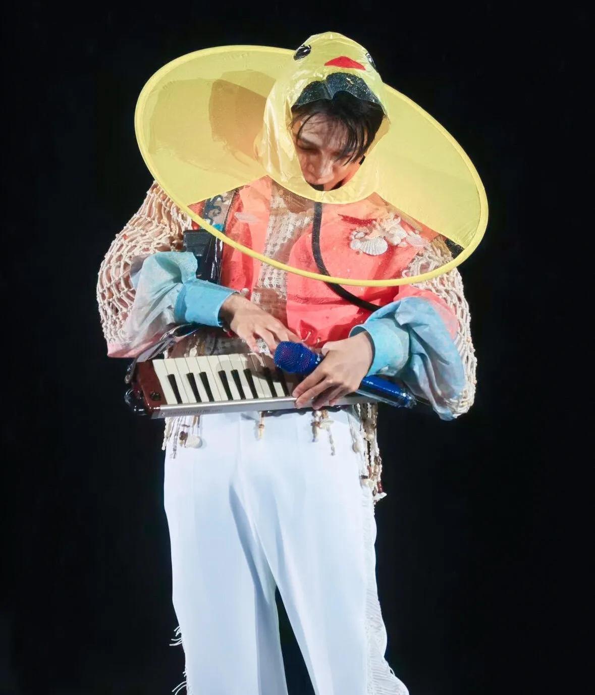 周深也太拼了！
下雨还坚持开演唱会！他戴着小黄鸭帽子，再穿粉色的上衣，在台上又唱