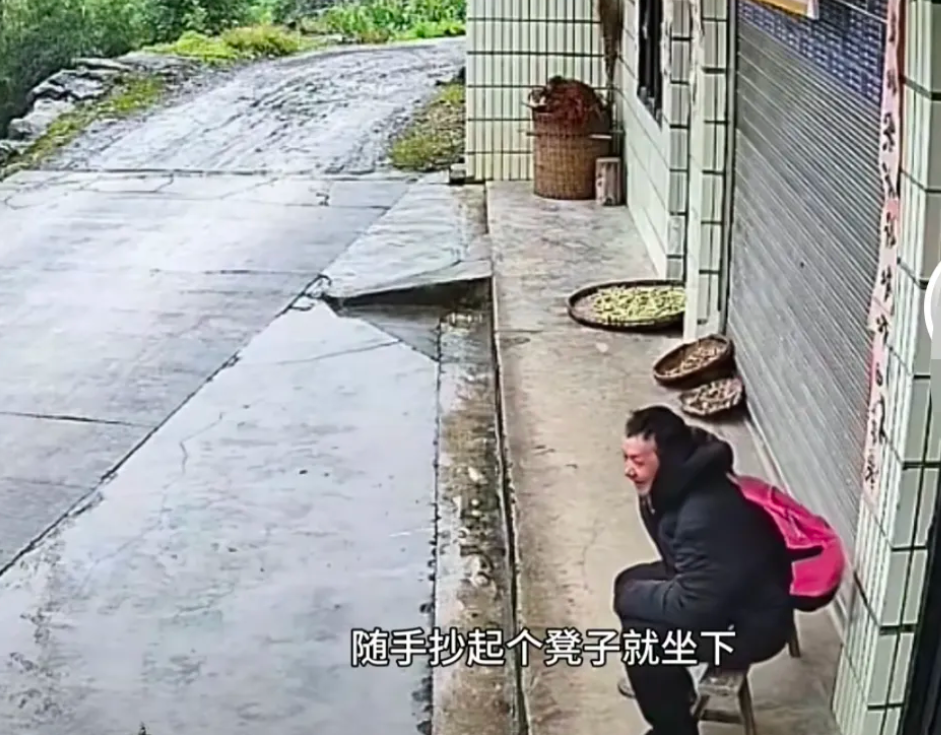 浙江天降大雨，一背包男子未带伞到一户人家屋檐下避雨，还拿过大爷家的凳子坐着，几分