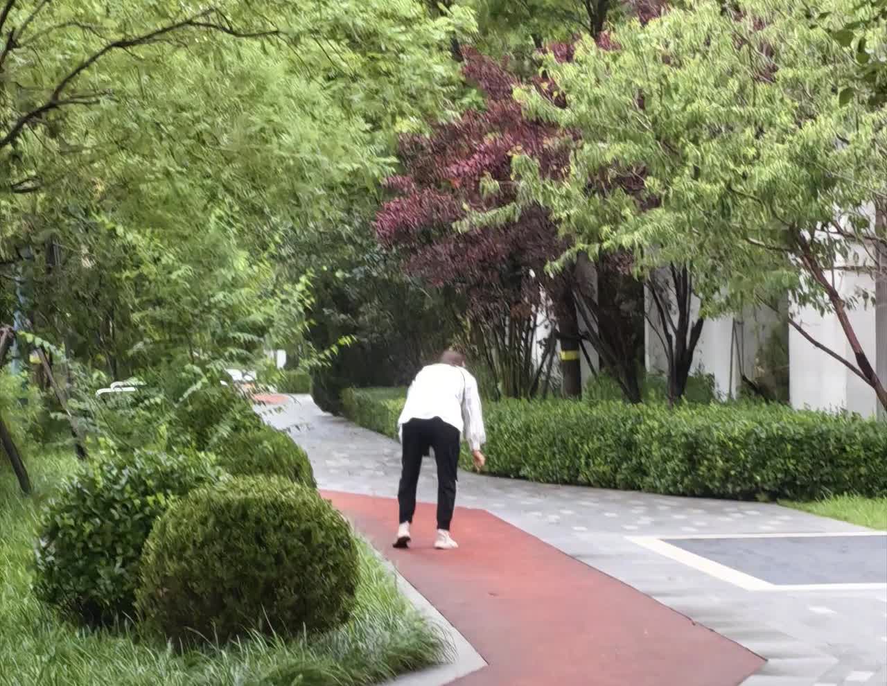晨跑，见一女子边走路边不时弯腰。起初我以为她在系鞋带，可不能鞋带总是松开呀。走到