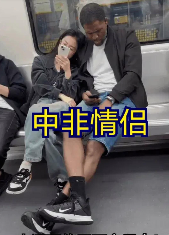 这是网友在地铁上拍到的一对“中非情侣”。

女子倚靠在黑人男友身边正在玩手机