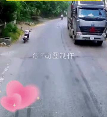 两岁左右的小孩子跑到了公路上，大货车发现后忙停了下来。小孩子可能跑累了，坐在了公