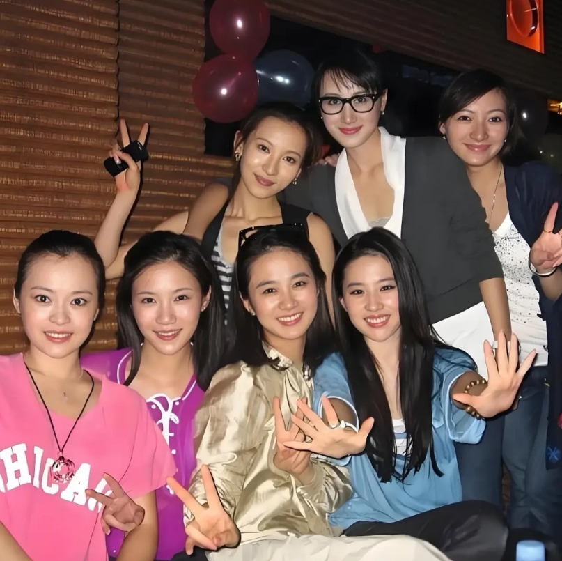 这是刘亦菲与六位大学同学聚会的照片，刘亦菲坐在前排的左边，她面对镜头不是打剪刀手