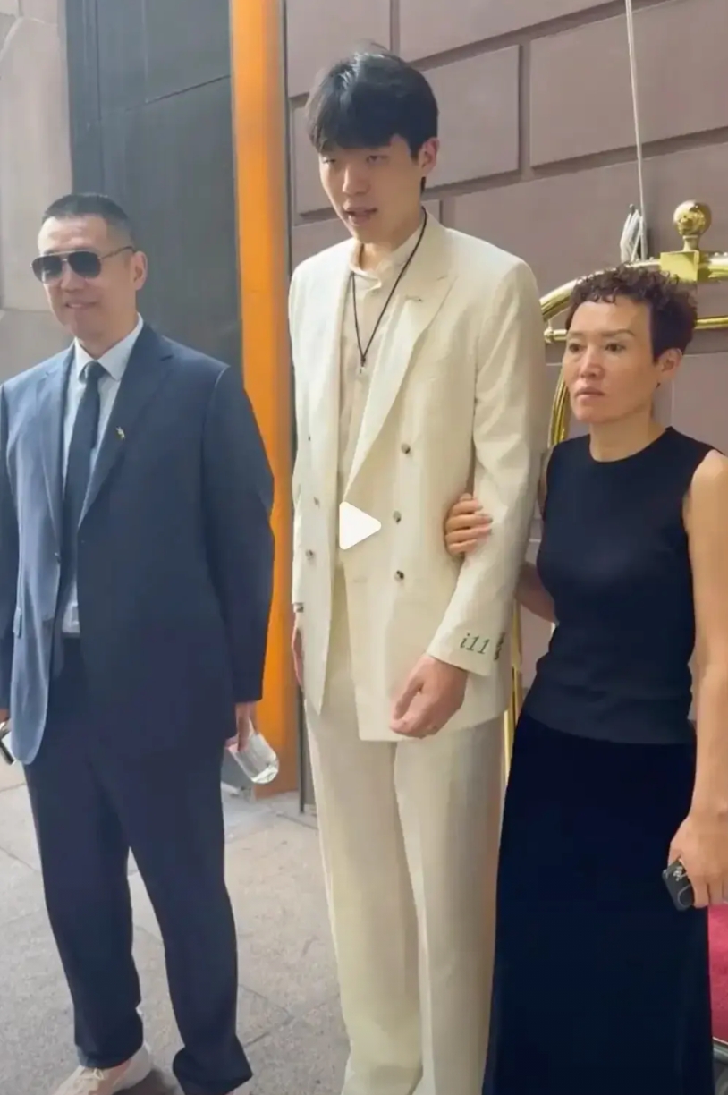 杨瀚森全家准备去现场，瀚森穿自制西服，爸爸有山东乡土味，妈妈表情严肃。
瀚森西服