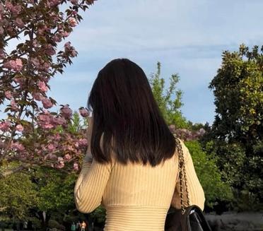 春风拂面来，小姐姐在公园散步，享受这美好时光。