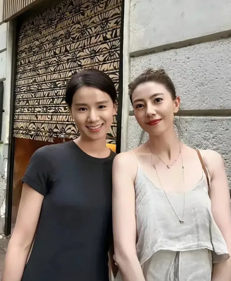 高圆圆在饭店与老板娘合影，很明显老板娘更漂亮啊！良家妇女穿着端庄得体，既不露胸也