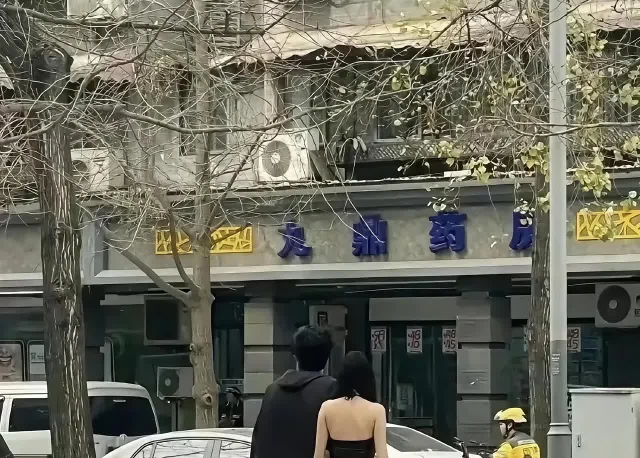 成都九鼎药房门口拍到一对男女朋友，他们的着装引起了争议。
有人说穿什么衣服是自