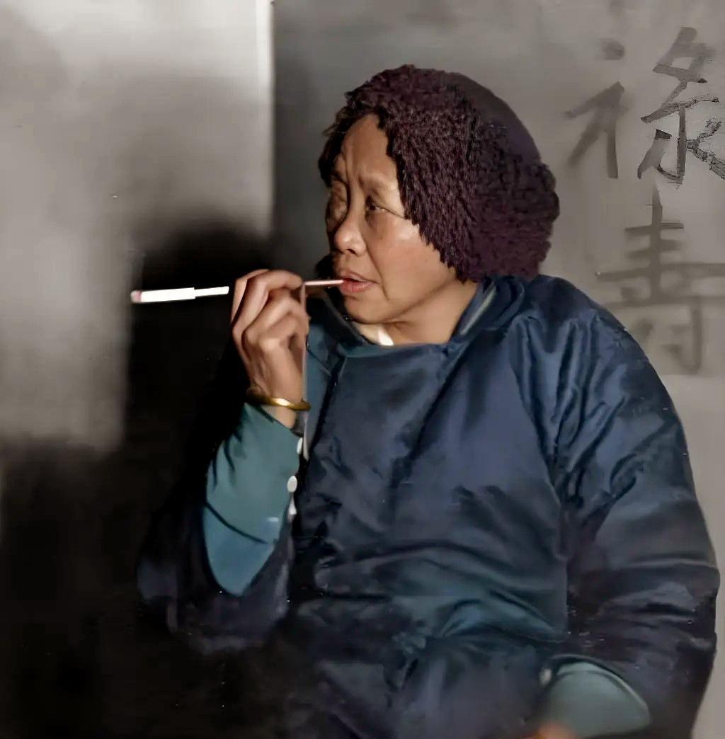 1927年，一个媒婆坐在椅子上，望着女方家人。她吸着烟，手上戴着很粗的金镯子，目