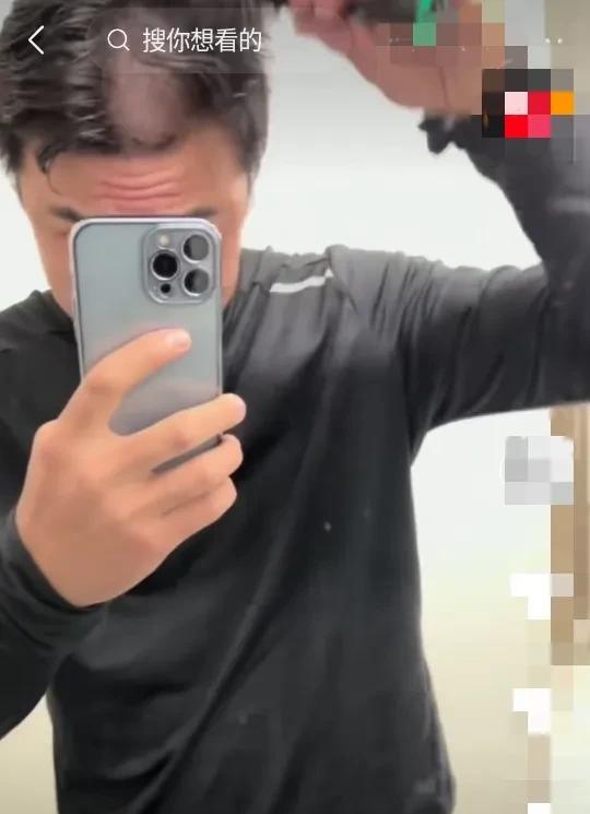 张名扬自己给自己理发，想不到张名扬还会自己理发 。
他是一手拿住手机，一手拿住电