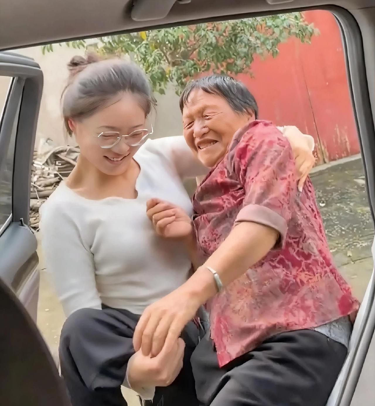 孙女先拉开前车门，连推带抱地把爷爷扶到副驾驶座，又打开后车门，直接将奶奶强行抱进