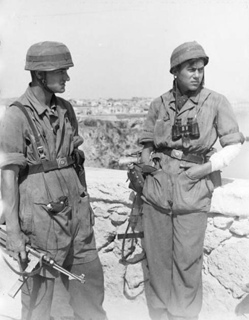 1941年5月（或6月），希腊，克里特岛。两名德军空降兵正在一堵石墙旁边休息。两