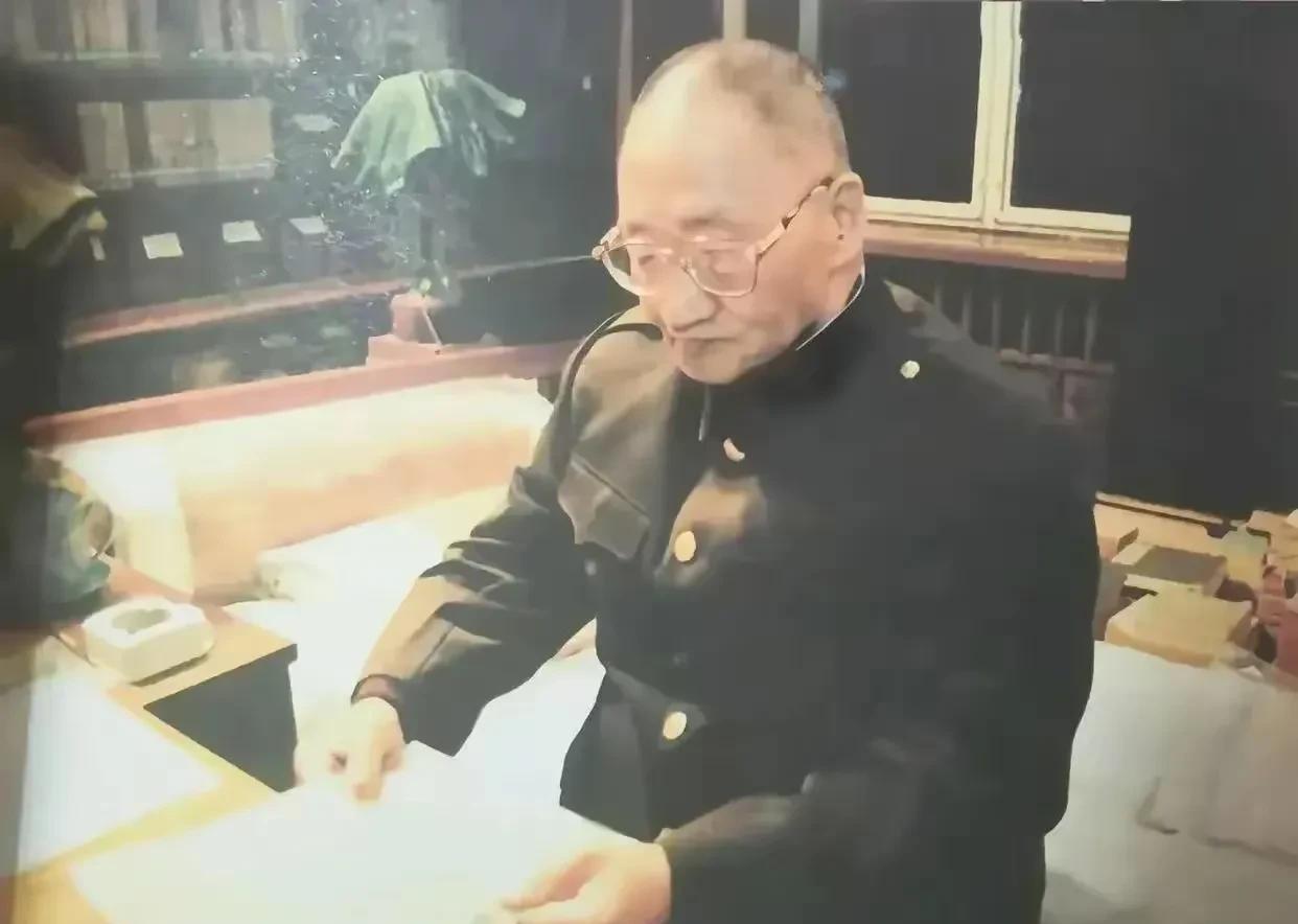 这是八十年代毛岸青坐在父亲的床上的照片，照片中他戴着眼镜，手里正在翻看父亲曾经浏