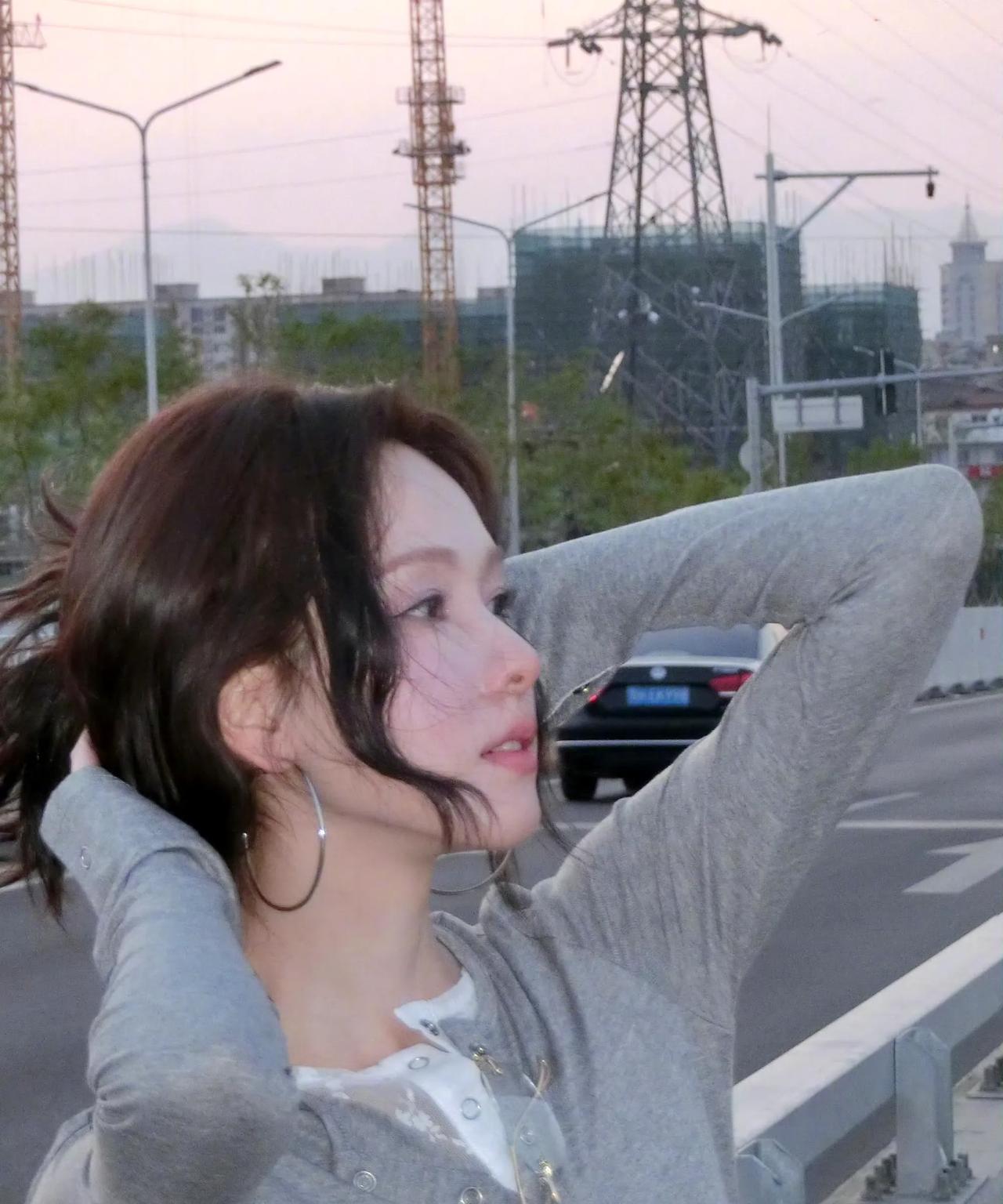 #陈都灵#灰衣格裙，漫步于城市边缘。手持相机，定格瞬间美好；发丝轻扬，邂逅晚风温