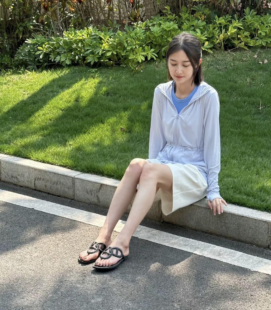 陈钰琪，165cm，坐在路边，阳光洒落在身上，整个人散发着慵懒随性的气息。