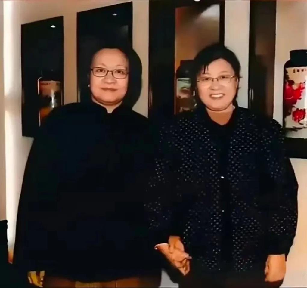 李讷是毛主席的小女儿，谢静宜曾在毛主席身边工作。她们亲密合影，双手紧扣，背后有着