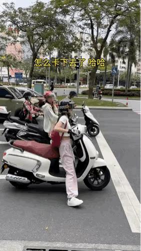 小姑娘的骑车姿势是怎么做到的呢？
这一个红绿灯处红灯亮起，一个小姑娘骑着摩托精准