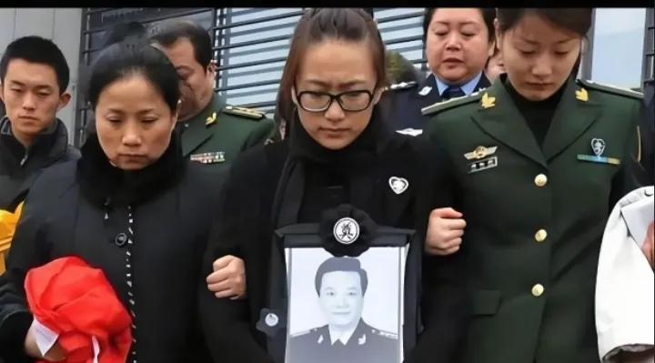2013年，相声演员王平的葬礼上女儿手捧父亲的遗像悲痛万分在亲人的搀扶下送别父亲