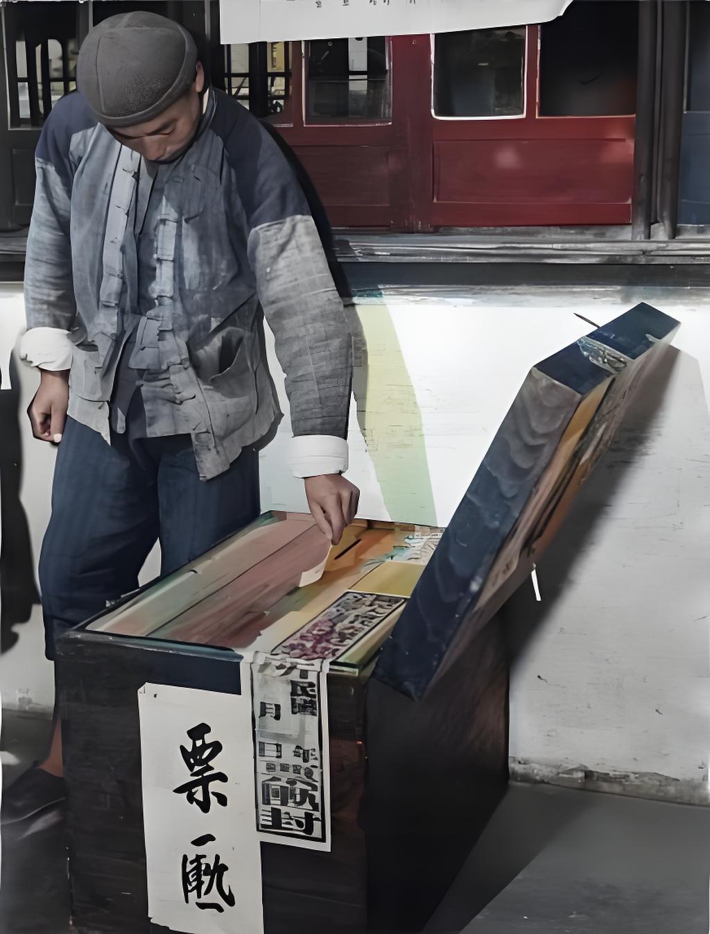 1948年上海，一名苦力工人正往票箱投选票。彼时国民党搞“行宪”选举，实为维护统