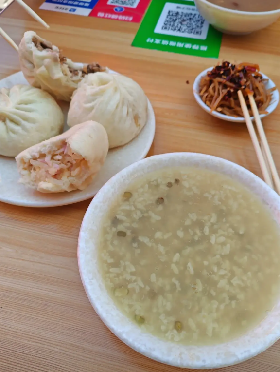 这是生存还是生活？
一个包子1.5元，一碗粥2元，随便喝。一碟咸菜1元。一般都是