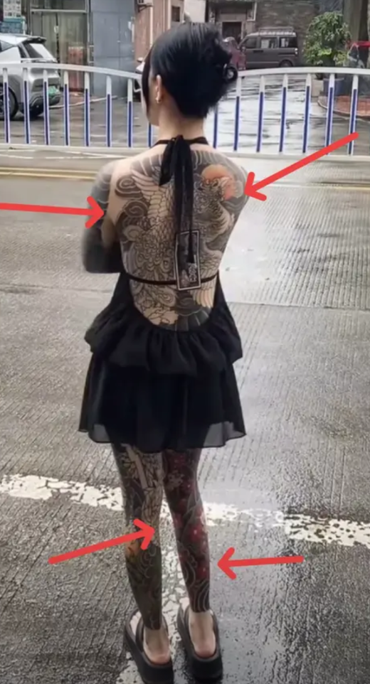 广东，一女孩全身都纹满了纹身，从脖颈到脚踝，全都纹上了各式各样的图案，路过的行人