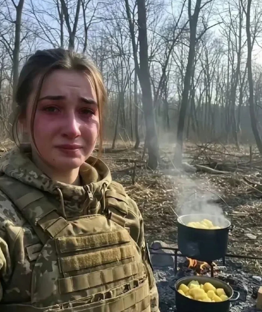 这是一位乌军女炊事员，负责连队的餐饮，两口锅里的食物热气腾腾，她在等待前线的战友