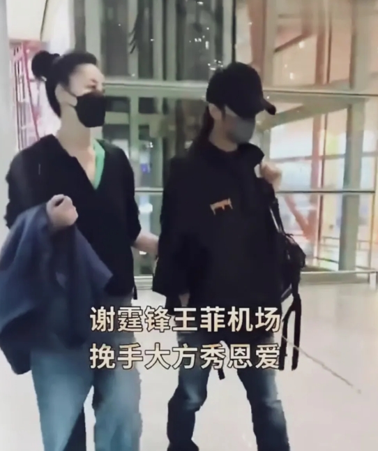 王菲谢霆锋机场亮相，挽着谢霆锋的手臂，王菲大大方方，谢霆锋一直低头走路，这两个人