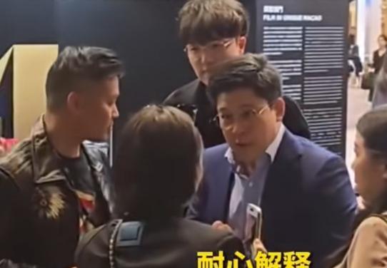霍启刚参加活动结束，正往外走，一群人围着他跟拍；甚至有位穿绿衣服的女子，一把搂住
