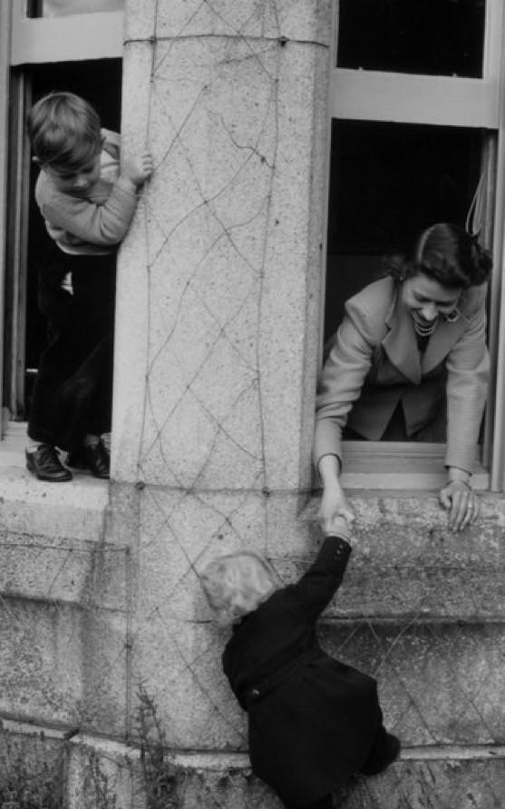 1952年的今天，
照片摄于巴尔莫勒尔堡，画面中女王陛下正从敞开的窗台探出身，协