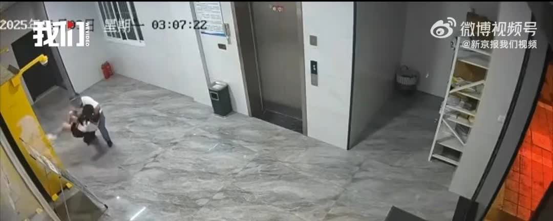 怎么敢的，一女子正在等电梯，一带头盔的男子从身后突然就把他抱了起来，女子激烈挣扎