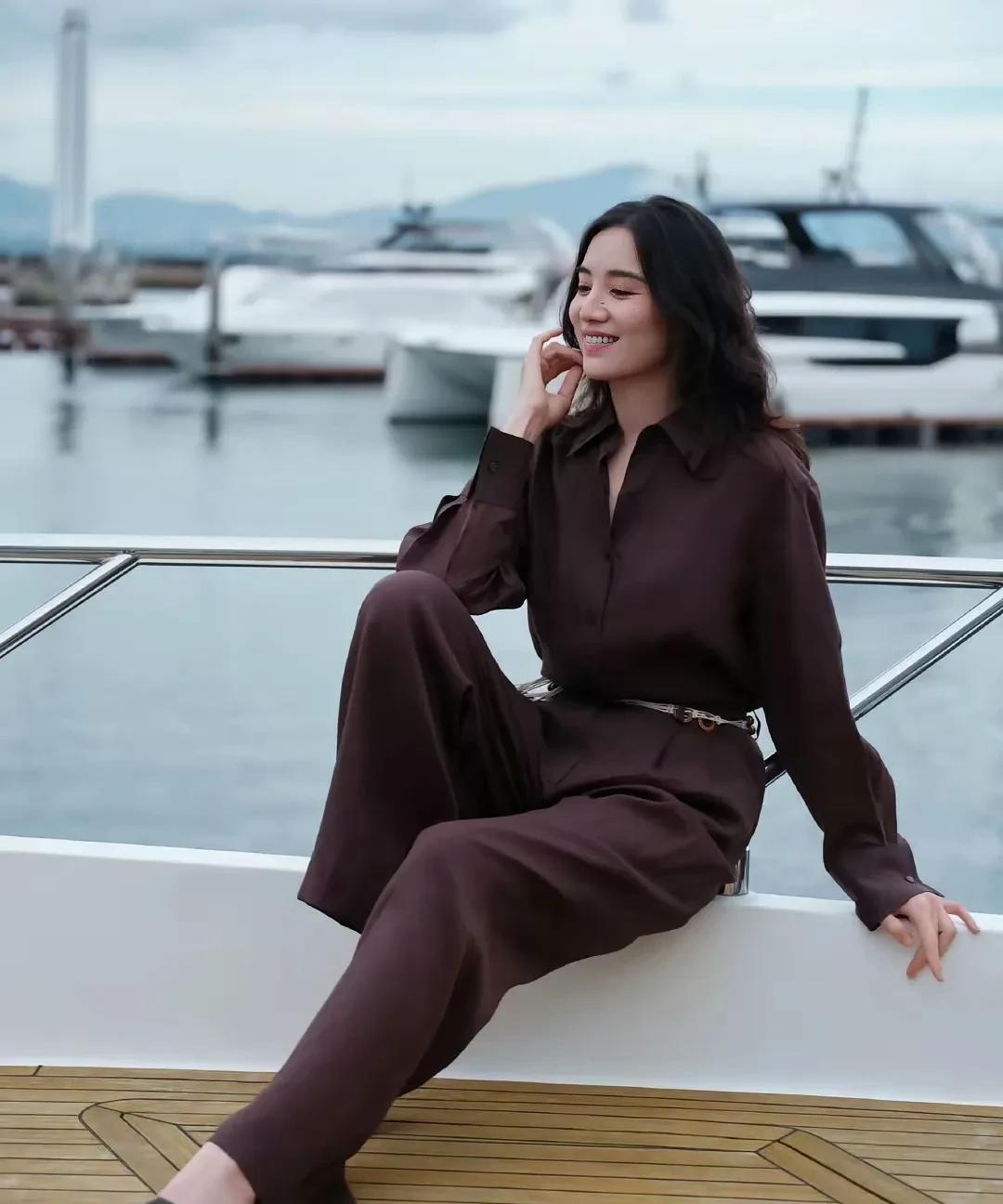 宋佳，身高173厘米，海边的优雅时光，棕色的连衣裙与游艇相映成趣。