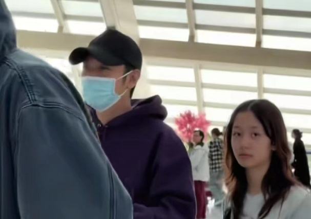 张丹峰现身机场接儿子和女儿回家
儿子张镐濂穿着牛仔衣，戴着帽子和口罩，看到镜头就