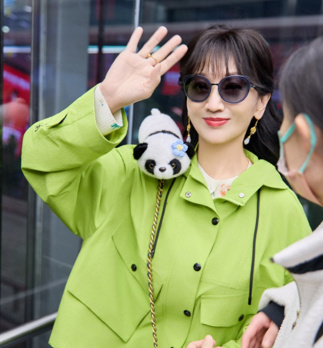 赵雅芝里面穿白色打底衫
外面套着绿色的宽松外套，两件衣服叠穿的效果很不错。
她下