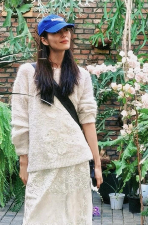 刘雯的穿衣风格裙子配靴子真的是甜酷又时髦
这次选择了一身白，米白色的落肩针织衫，