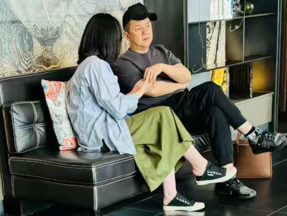 第一眼李亚鹏跟陌生女人牵手

旁边的人是他的女儿李嫣，李嫣穿一件蓝色衬衫，搭配绿