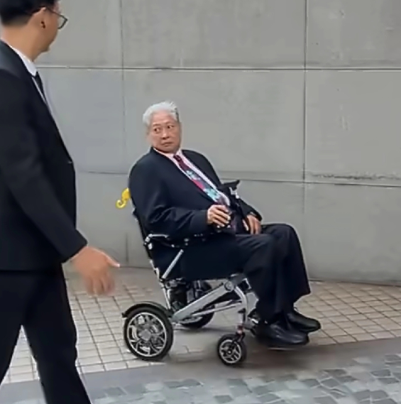 洪金宝坐着轮椅出席活动身穿黑色西装
梳着标志性大背头，精神看着还不错，但大家第一