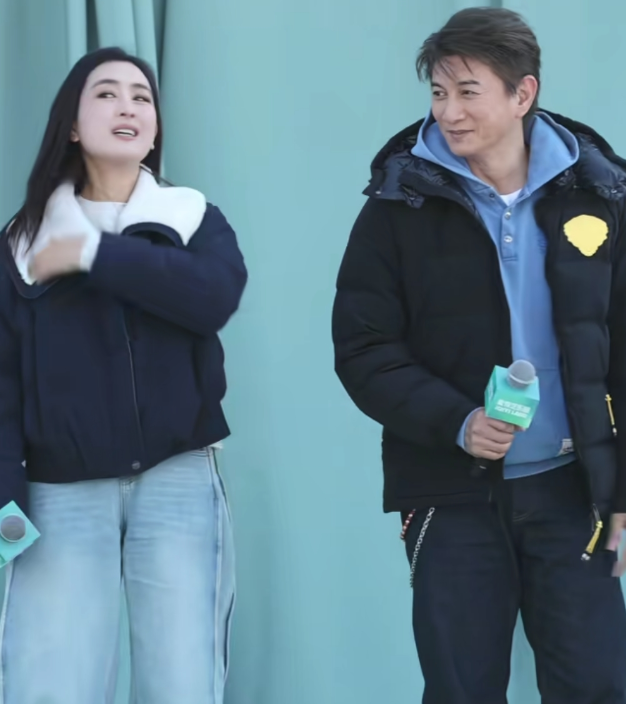 吴奇隆蓝卫衣配黑羽绒，单手插兜笑得一脸松弛旁边站着马苏，俩人都是许久不见的老面孔