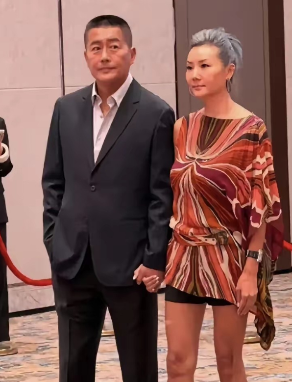 61岁的高曙光和48岁的妻子王玲一起出席活动
王玲的形象不错，高挑长腿，气质满满