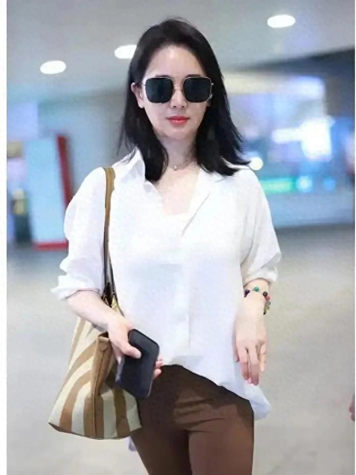 左小青身穿白色衬衫搭配咖色微辣裤，简直女明星范儿“十足”